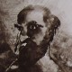 Ce détail d'un dessin de Victor Hugo représente un homme barbu et chauve, au regard fixe, auréolé de lumière et tourné vers l'ombre.